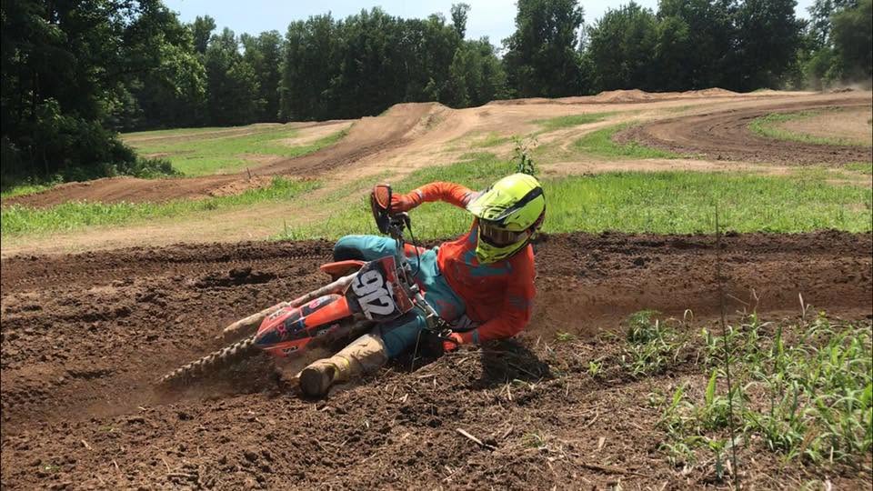 Rider leaning into a fast dirt corner on the track