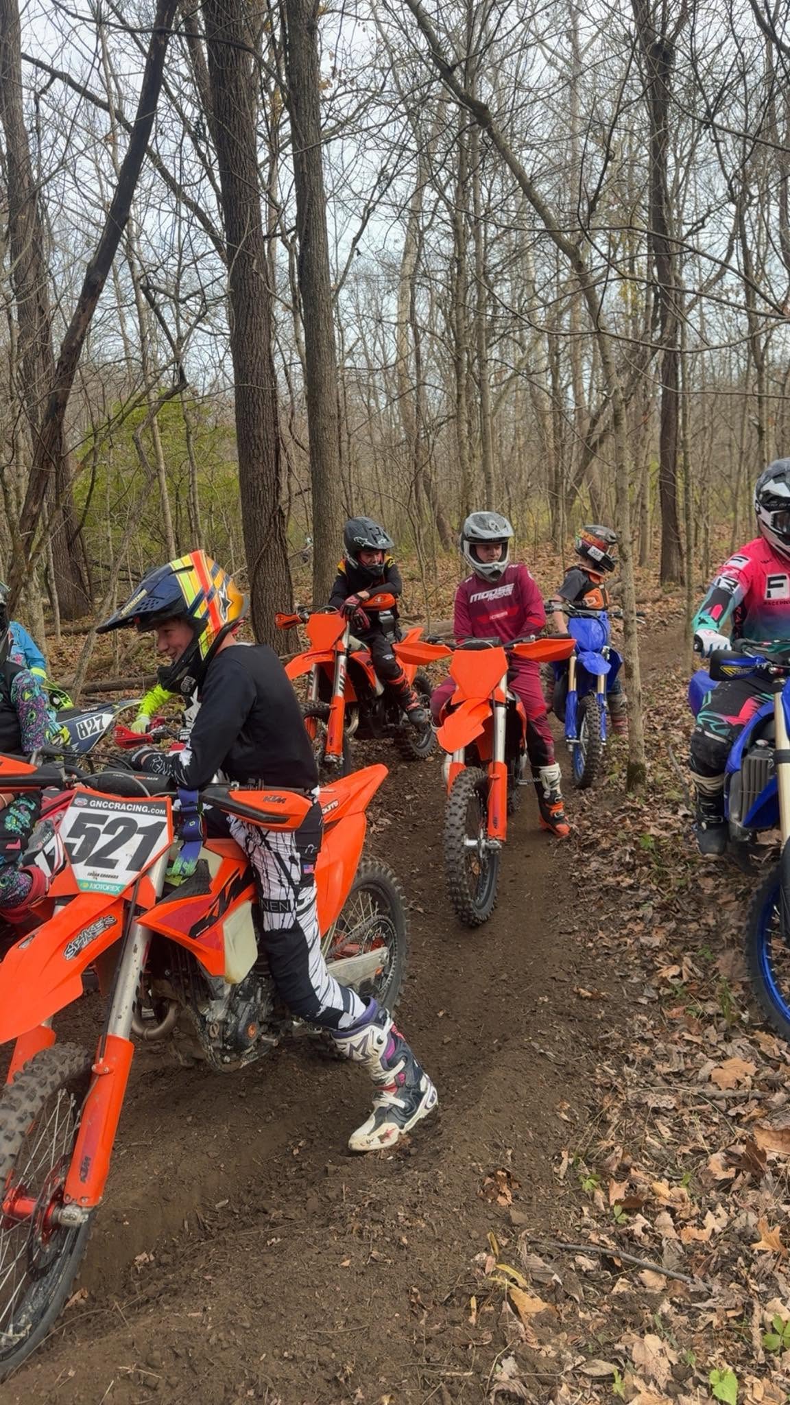 Group of riders pausing on a wooded trail during a training session